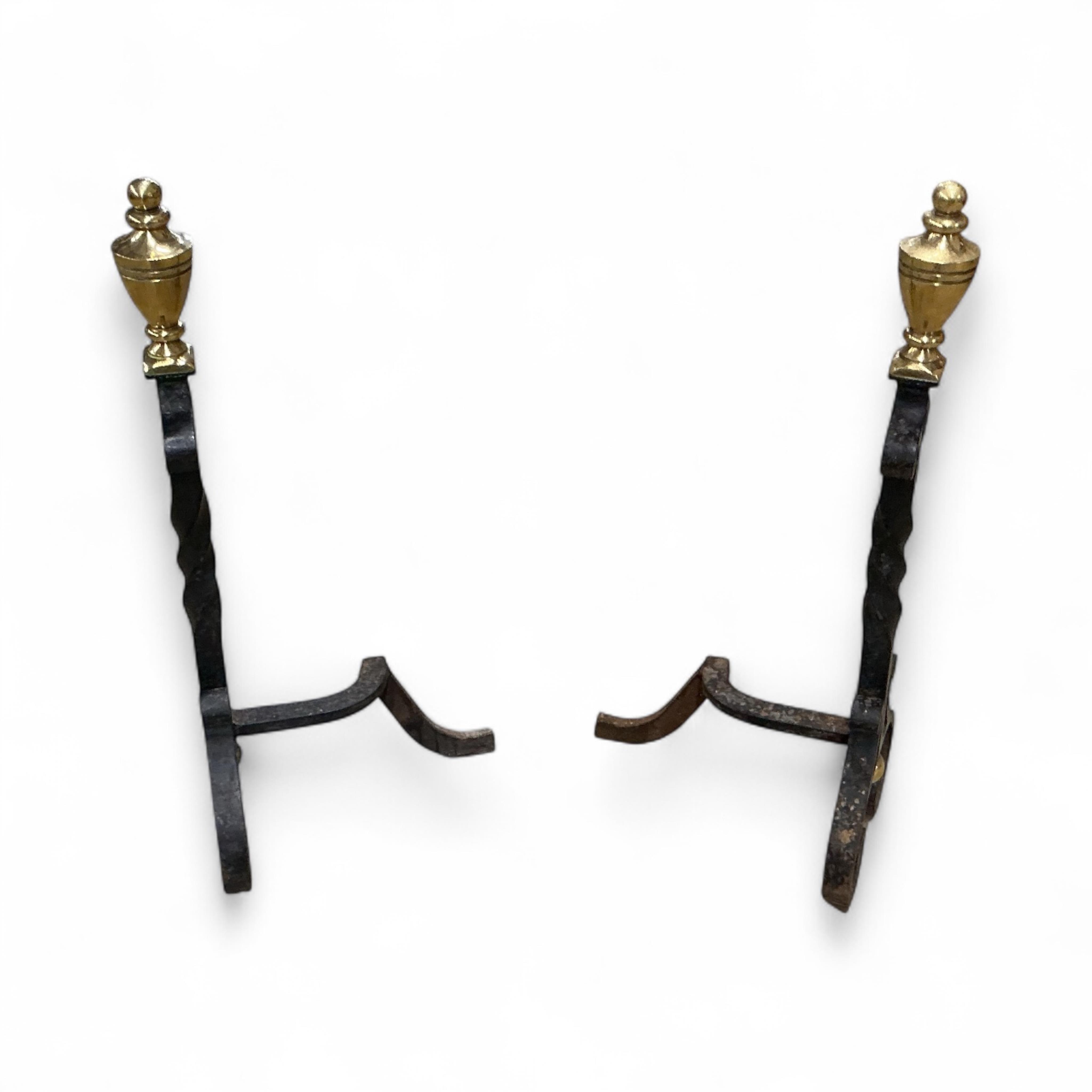A pair of wrought iron and brass tipped fire dogs together with a black painted iron and wire mesh three fold spark guard and one other spark guard